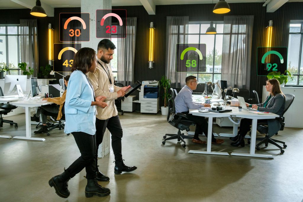 Multiple people in an office setting, each showing score above their head from measuring human risk assessment.