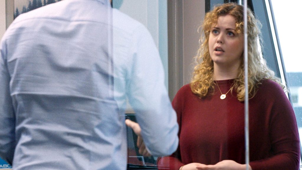 Snapshot from AwareGO's cybersecurity awareness training video about insider risk. A female supervisor is having a serious talk with a male employee.