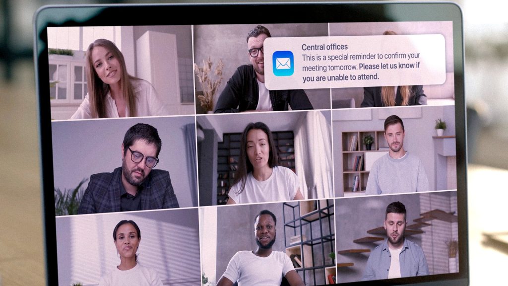 Snapshot from AwareGO video about accidental insider risk when working from home. A working from home computer can pose a risk if left unattended. Photo shows multiple faces at an online meeting and an email notification about an important meeting popping up.