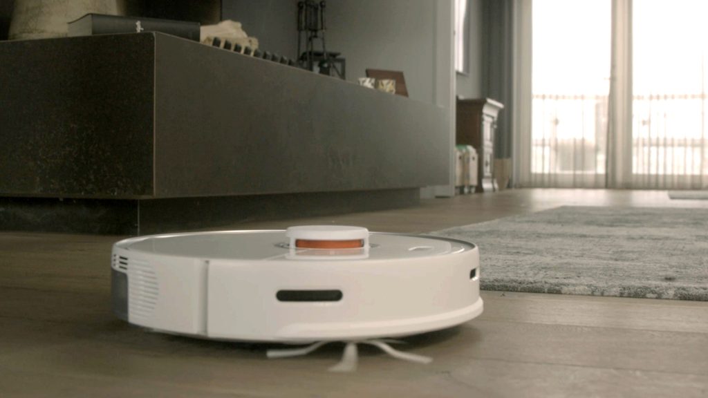 Inside a smart home. White robot vacuum cleaner working. Connected to the internet this smart device could be used for a cyber attack.