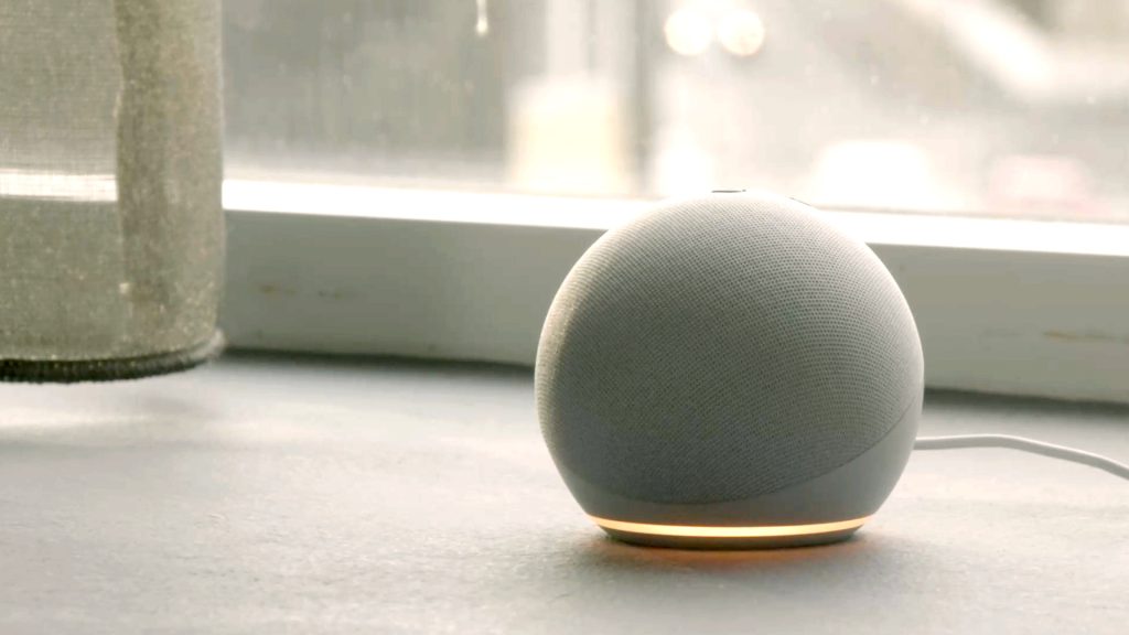 White smart device speaker inside a home with light on. Could be used for cyber attack.